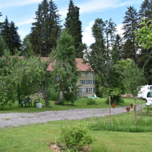 Blick auf Stellplatz und alten Hof inmitten der Natur