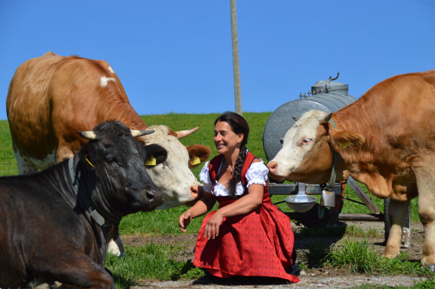 Gastgeberin Alex inmitten von Kühen auf der Weide