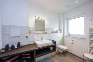 Badezimmer mit Waschbecken und WC und Handtuchtrockner