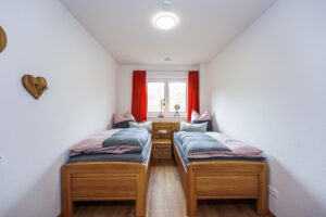 Doppelzimmer mit zwei Einzelbetten aus Echtholz
